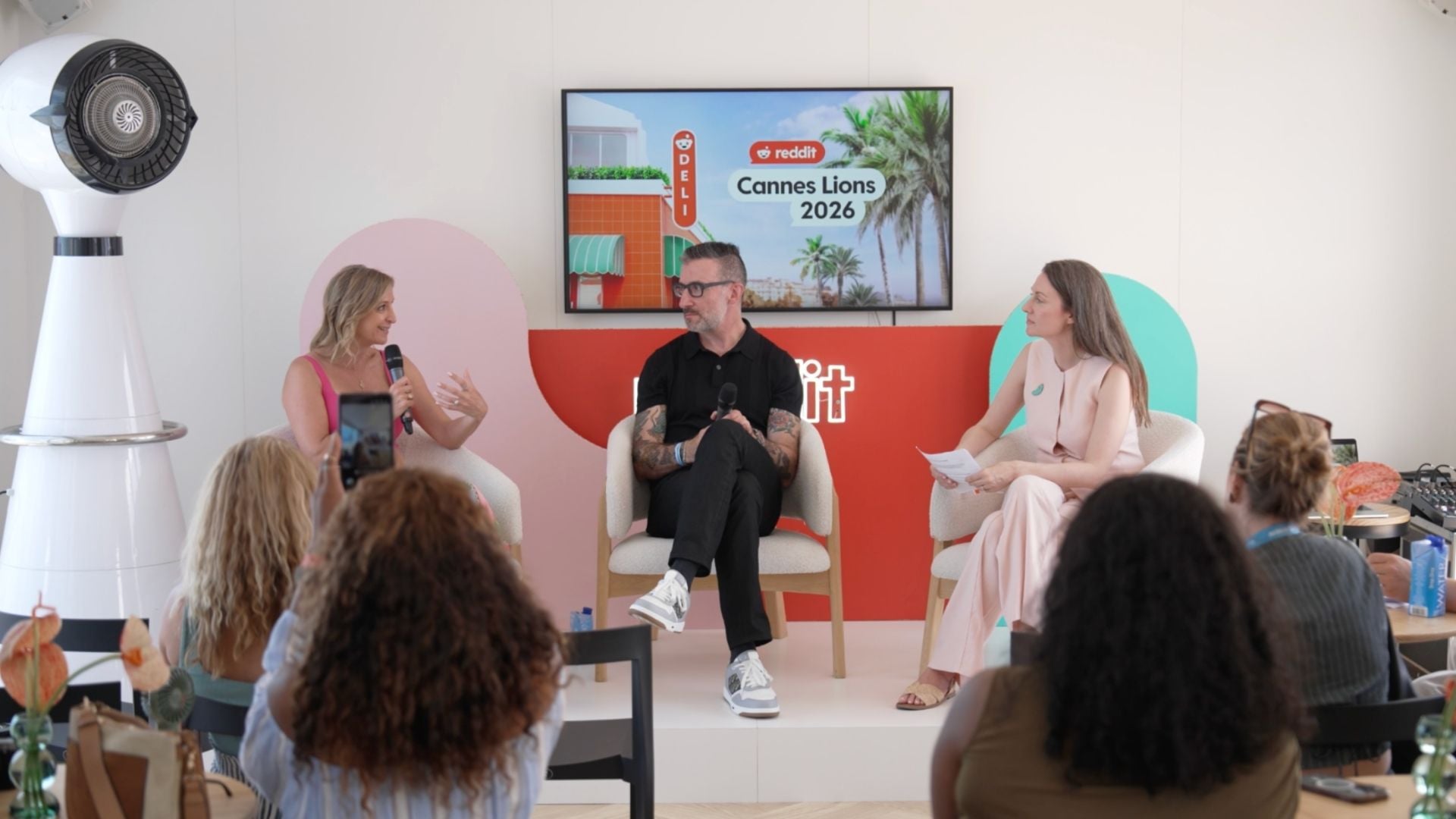 Three panelists at a Reddit Cannes Lions 2026 session, shown as background context for Reddit advertising