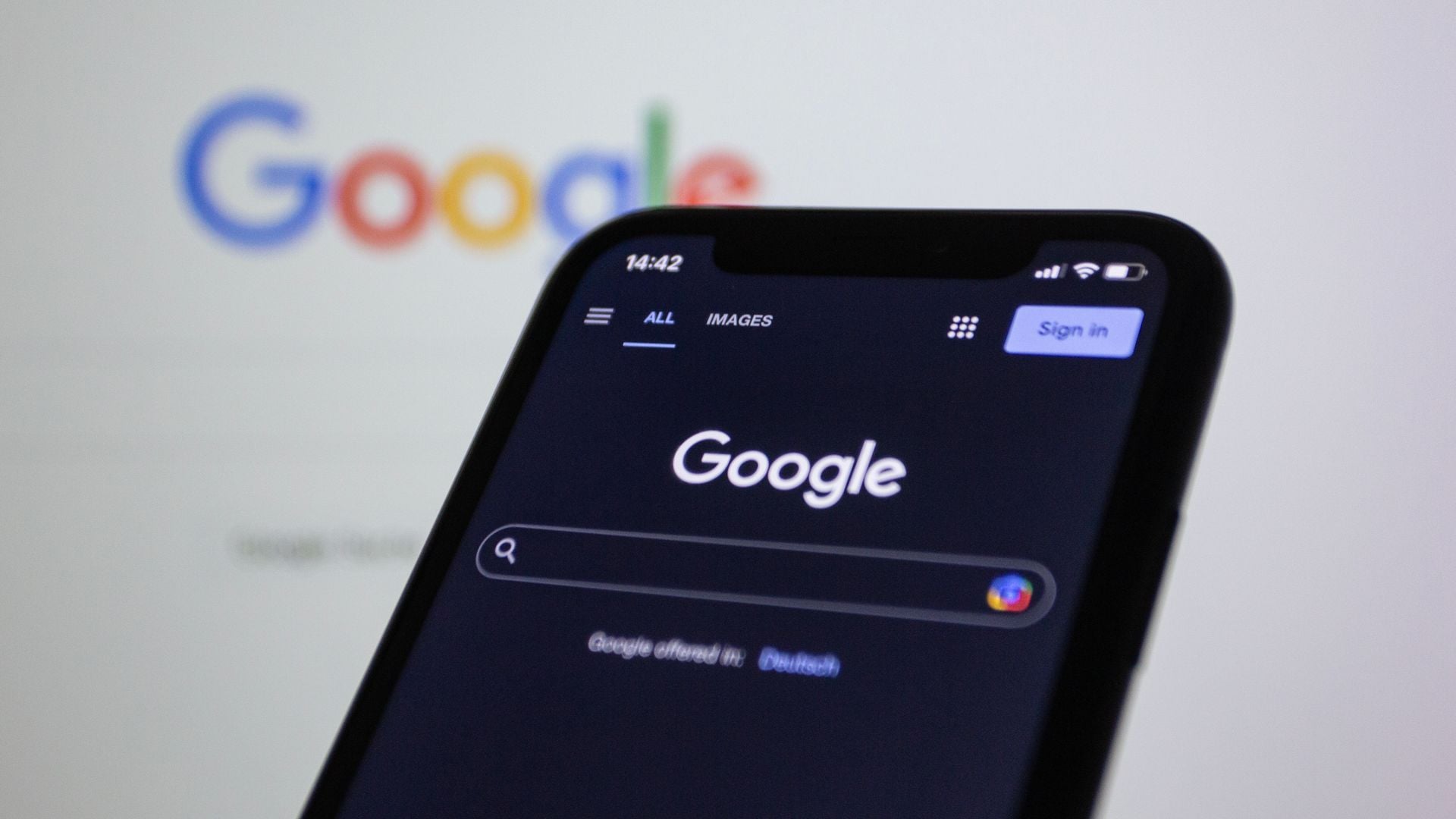 Google Search open on a smartphone in front of a larger Google logo