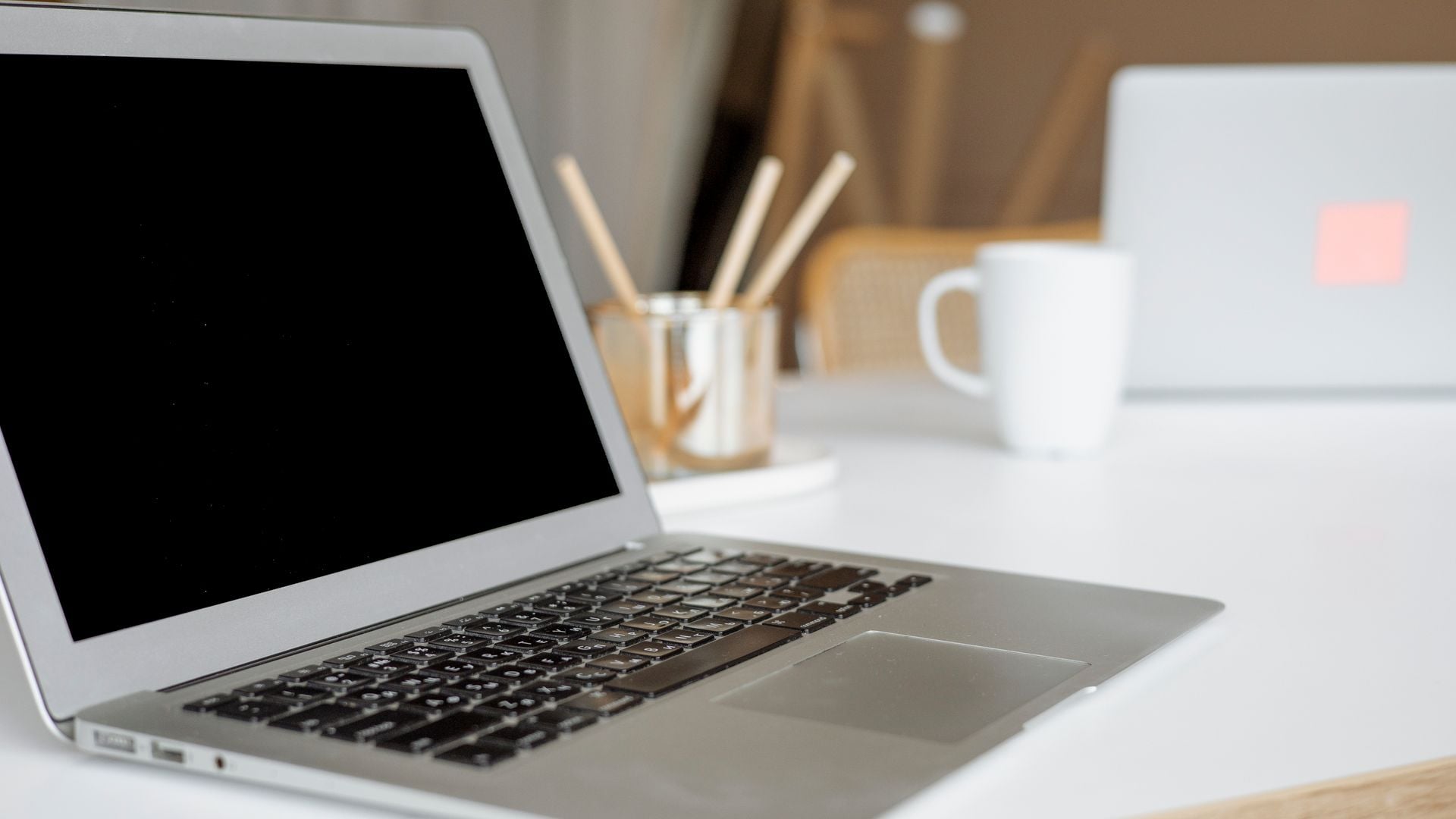 Open laptop with a blank display on a white desk