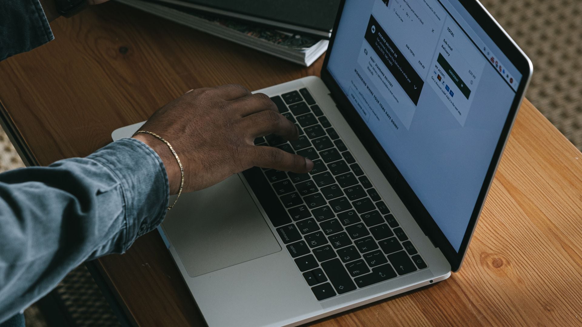 A person uses a laptop showing an online shopping checkout page.