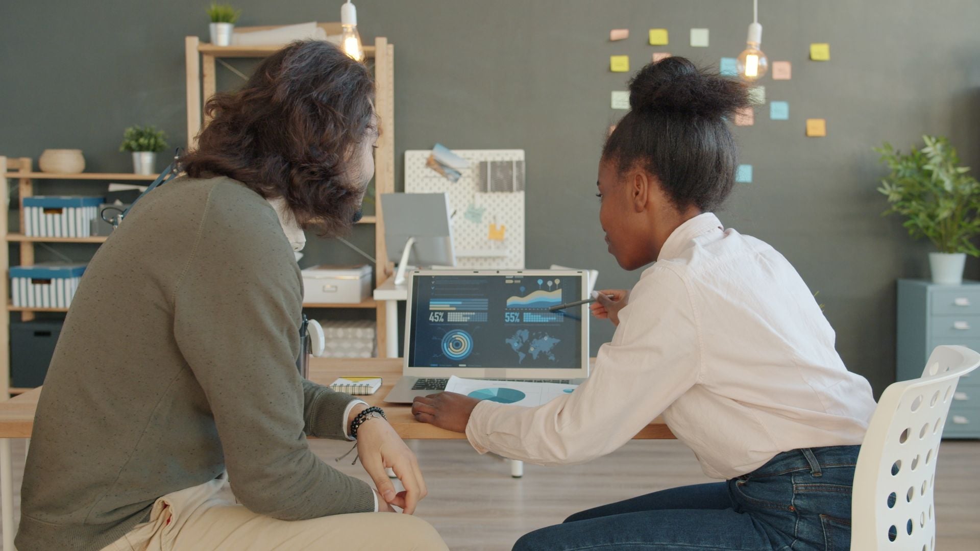 Two colleagues reviewing analytics on a laptop in an office