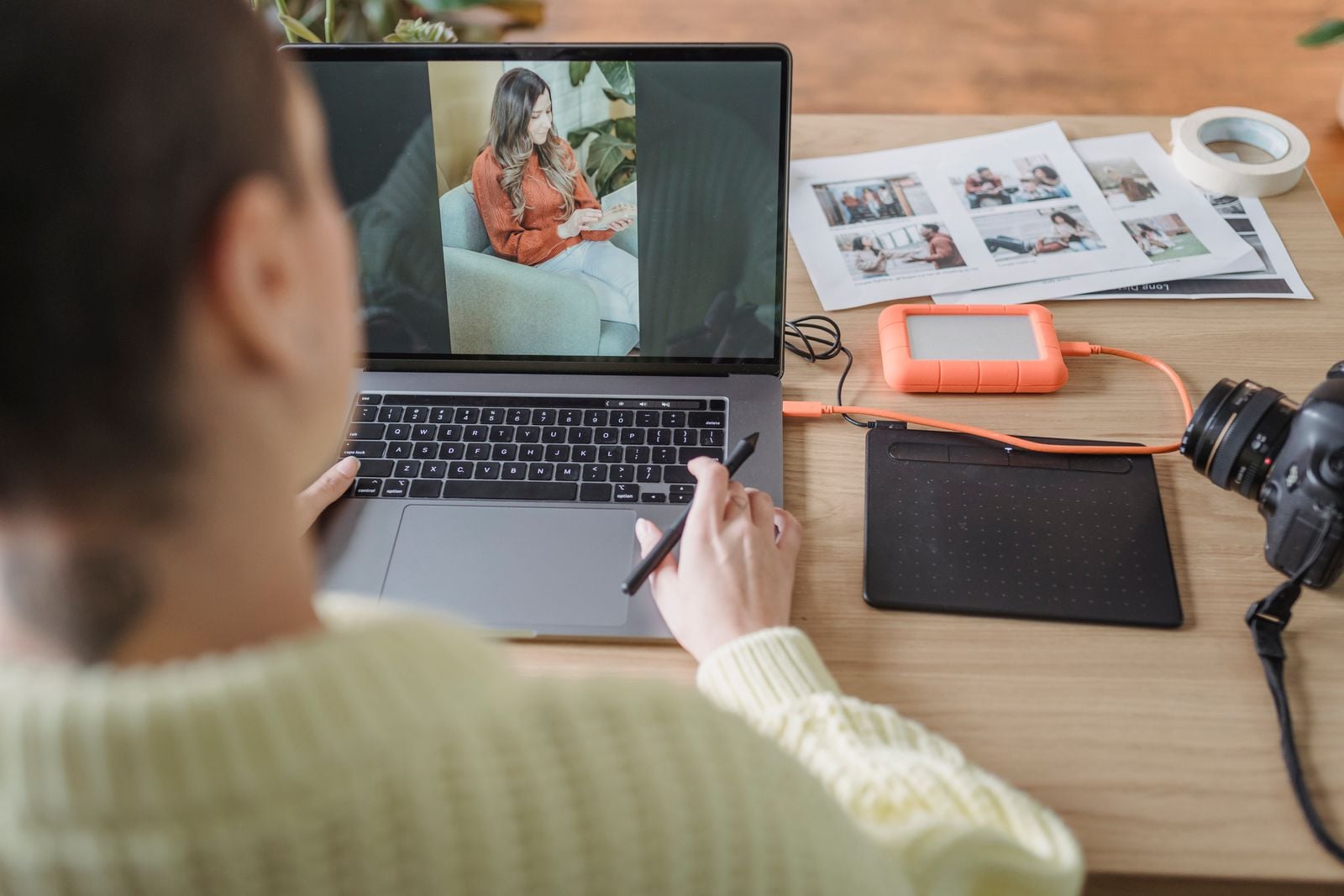 A photographer editing an image on a laptop beside camera equipment
