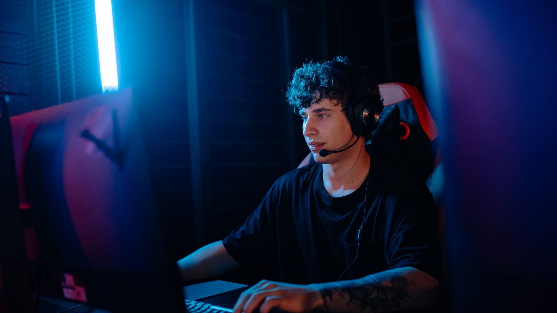 A person wearing a gaming headset at a desktop computer