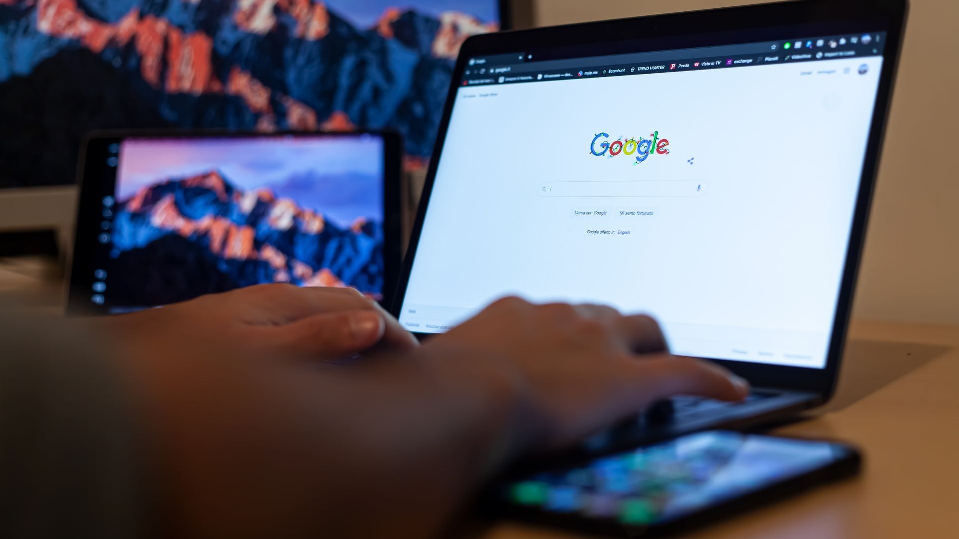 Hands using a laptop with Google open on its screen