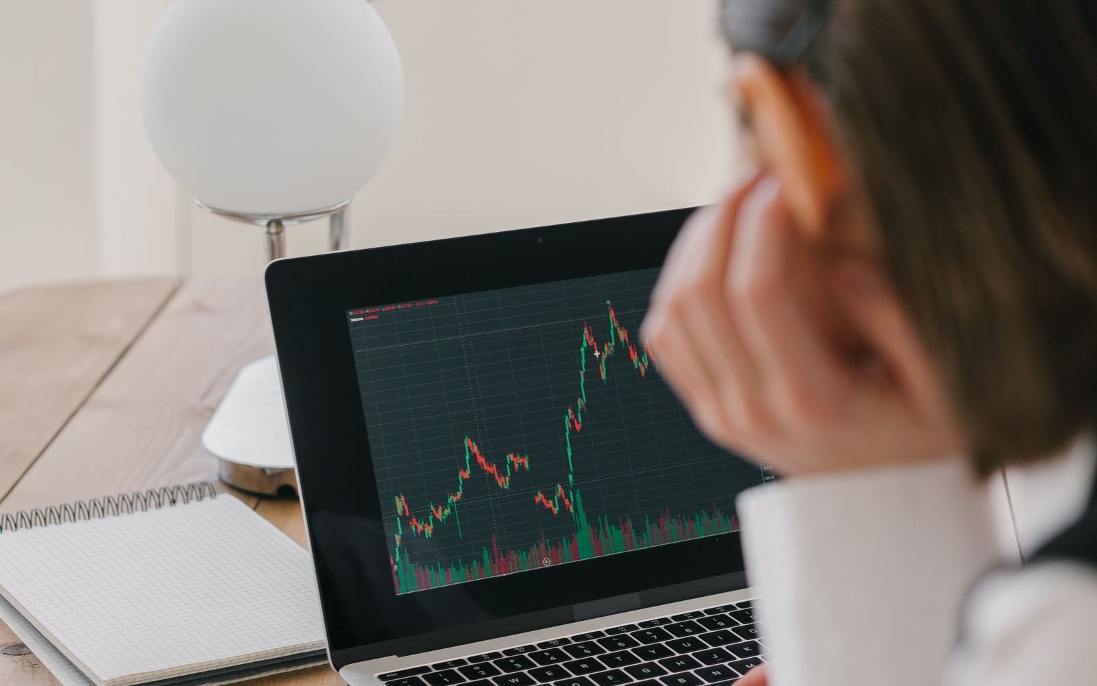 Person looking at financial charts on a laptop