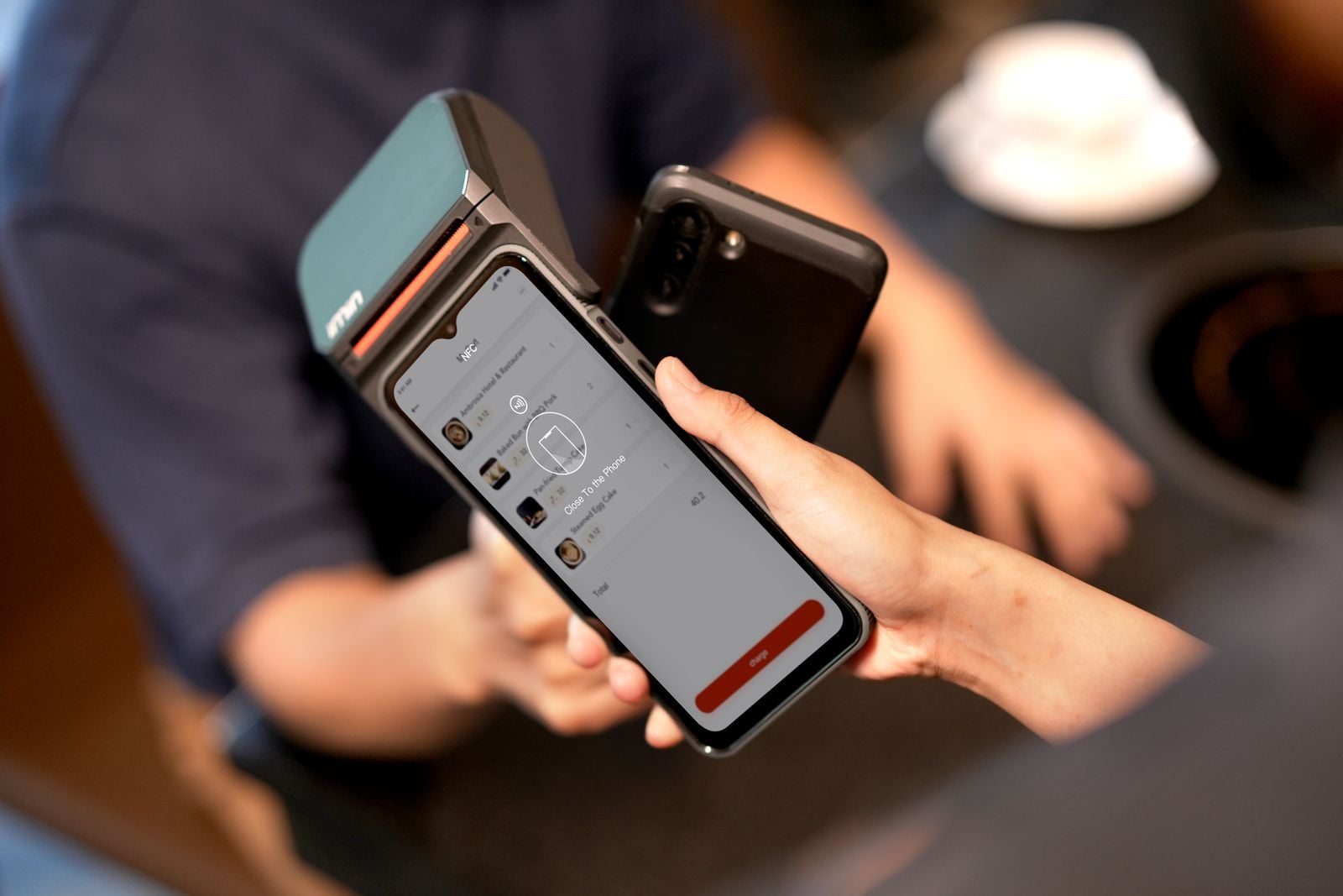Customer holds a phone near a payment terminal