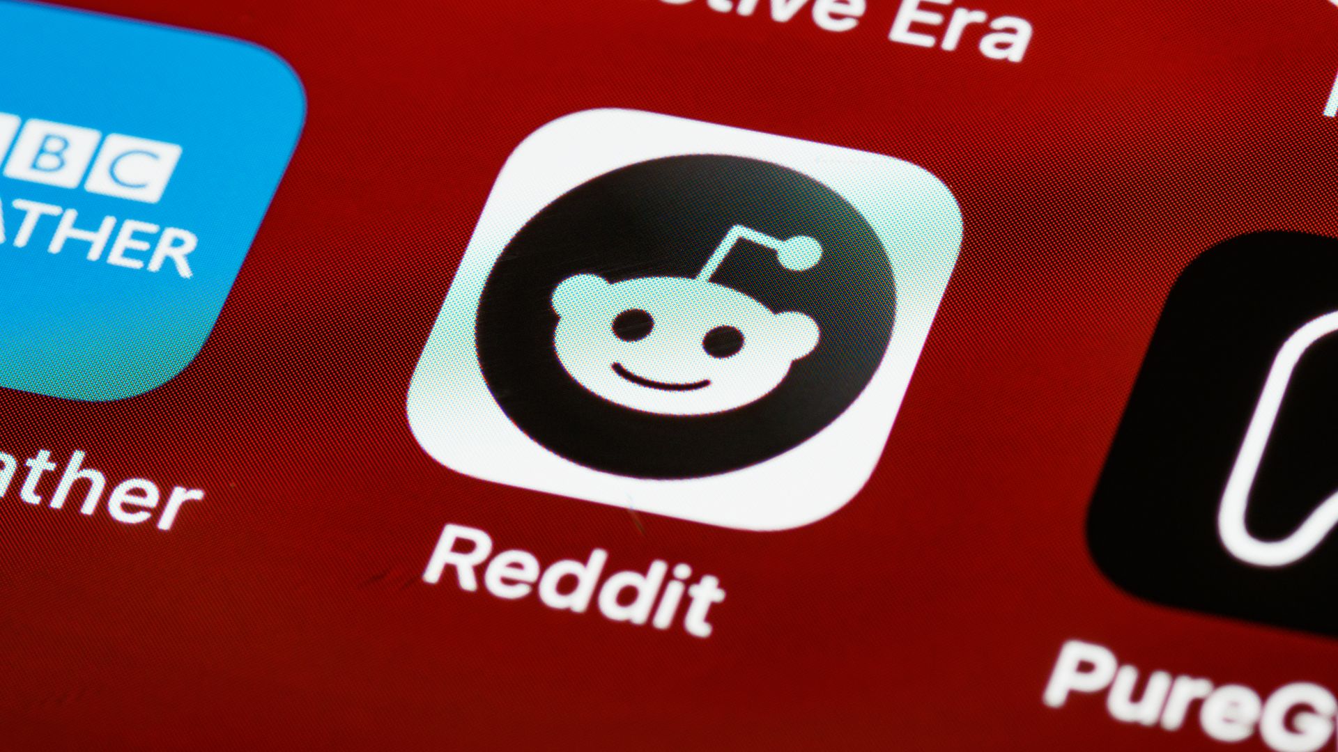 Reddit app icon on a smartphone screen with a red background