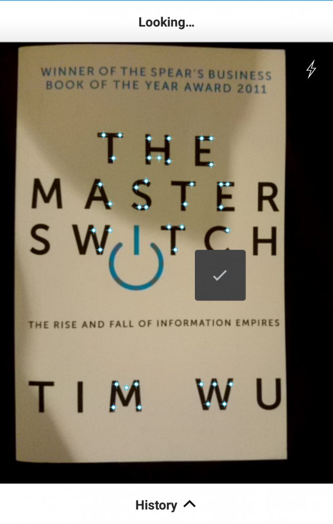 A screenshot of Amazon's visual search for its mobile app in action. The main part of the screen shows the cover of a book, The Master Switch by Tim Wu. A collection of bright blue points clings to the title and author, and a tick icon shows that the app has successfully identified the book.