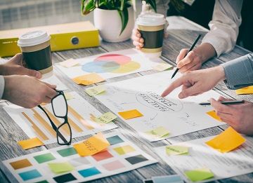 Photograph of people brainstorming around a table.